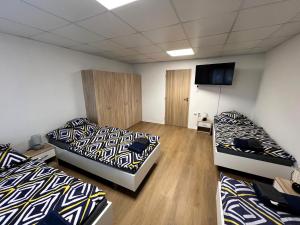 a room with two beds and a flat screen tv at Apartmány Škodova Přerov in Přerov