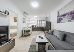 a living room with a couch and a table at The Beachfront Bliss by PS in Golem