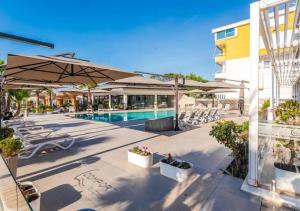 a patio with a pool and umbrellas next to a building at The Beachfront Bliss by PS in Golem