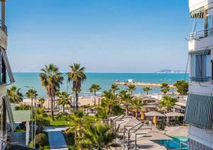 a view of the beach from the balcony of a resort at The Beachfront Bliss by PS in Golem