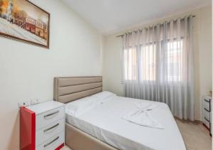 a white bedroom with a bed and a window at The Beachfront Bliss by PS in Golem +24 photos