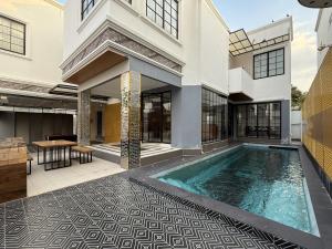 a swimming pool in the middle of a house at Pool Villa Pattaya 5BD - Exquisite Pool Villa G in Nong Prue