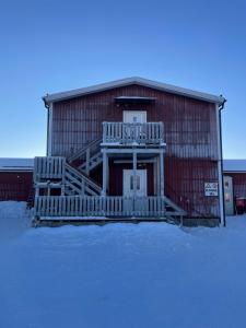 a red barn with a porch in the snow at Laplanders room 15 in Kiruna +4 photos