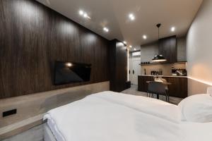 a bedroom with a large bed and a tv on a wall at EVURI Apartments BUDAPEST 2 in Uzhhorod