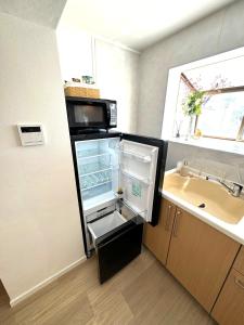 a refrigerator with its door open next to a sink at K-ART Stay Shinsakae2 in Nagoya +198 photos