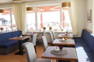 a restaurant with tables and chairs and windows at Hanseat in Helgoland