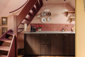 a kitchen with brown cabinets and a purple staircase at Atteheem in Breukelen +17 photos