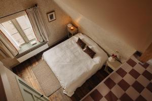 a small bedroom with a white bed and a window at Atteheem in Breukelen