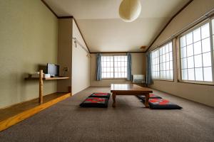 a room with a table and some windows at 北国ロッヂ in Otari