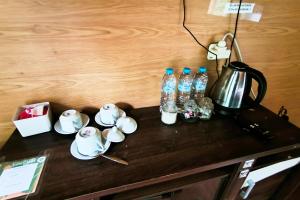 a table with bottles of water and a tea kettle at Spekta Merbabu powered by Cocotel in Jlarem