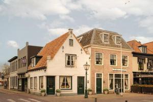 a white building with green doors on a street at Atteheem in Breukelen