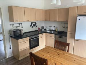 a kitchen with wooden cabinets and a table with a microwave at Ferienwohnung Achelpöhler in Hagen im Bremischen