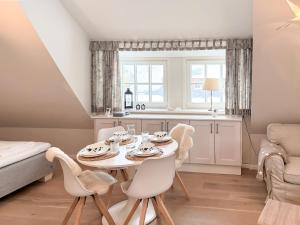a dining room with a table and chairs and a bed at Juwel in Keitum