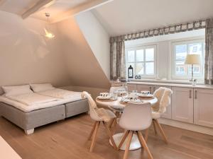 a room with a bed and a table and chairs at Juwel in Keitum