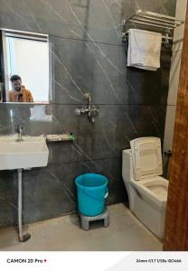 a man taking a picture of a bathroom with a toilet and sink at Hotel Pushkar Town in Pushkar