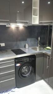 a kitchen with a washing machine and a sink at The Pearl of Marais in Paris