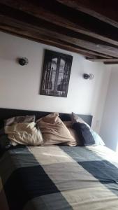 um quarto com uma cama com almofadas em The Pearl of Marais em Paris