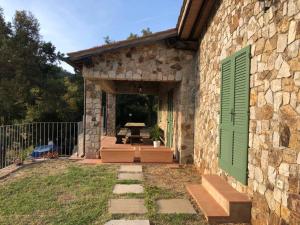 a stone building with a green door and a patio at Apartments La Tenuta where the sea meets the land - Goelba in Porto Azzurro +4 photos