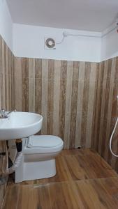 a bathroom with a toilet and a sink at Sandy Steps in Varkala