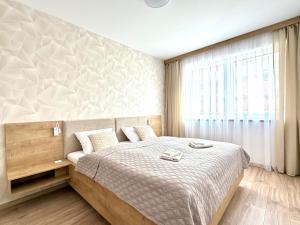 a bedroom with a large bed and a window at Lúka Palúdzka in Liptovský Mikuláš
