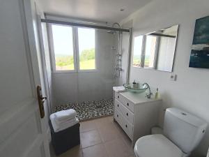 a bathroom with a sink and a toilet and a window at Le Charme des Bastides in Castelnau-de-Montmiral