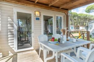 a table and chairs on the porch of a house at Club del Sole Spina Family Collection in Lido di Spina