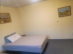 a room with a bed and two pictures on the wall at 70 m2 Anneks på gården in Malling