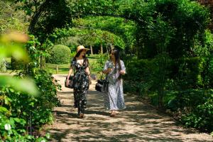 two women walking down a path in a garden at Waldorf Astoria Versailles - Trianon Palace in Versailles