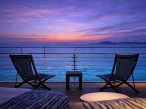 two chairs and a table in front of the ocean at KAMENOI HOTEL Ako in Ako