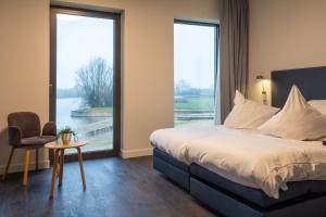 ein Schlafzimmer mit einem Bett und einem großen Fenster in der Unterkunft Domein Polderwind in Zuienkerke