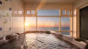 a bath tub in a bathroom with a window at Youngduk Sea & Spa Pension in Yŏngdŏk +4 photos