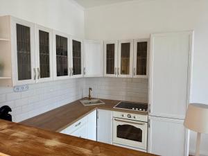 Eine weiße Küche mit weißen Schränken und einer Spüle in der Unterkunft Maxplatz in Rehau