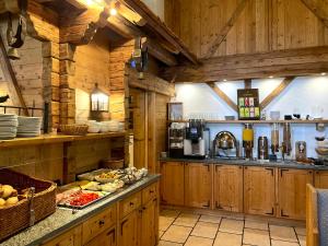 a large kitchen with wooden walls and wooden cabinets at Gasthof & Hotel Jägerwirt in Aufhofen +12 photos