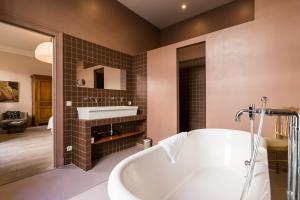 a bathroom with a white tub and a sink at Les Chambres du Vaudeville in Brussels +59 photos