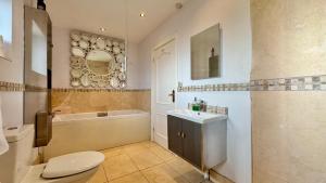 a bathroom with a toilet and a sink and a tub at AEL-Y-BRYN-5 BED- DRAMATIC SEA VIEWS - Sleeps 12 in Trearddur +41 photos