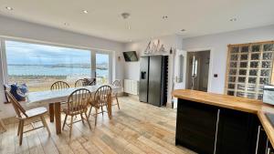 a kitchen and dining room with a table and chairs at AEL-Y-BRYN-5 BED- DRAMATIC SEA VIEWS - Sleeps 12 in Trearddur