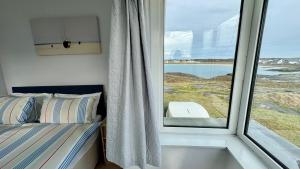 a bedroom with a window with a bed and a view at AEL-Y-BRYN-5 BED- DRAMATIC SEA VIEWS - Sleeps 12 in Trearddur
