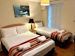 a hotel room with two beds with towels on them at Marine Apartment in Aberystwyth