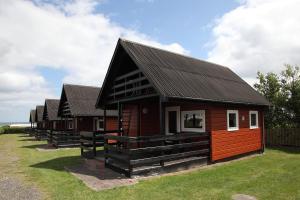 a row of small wooden houses on a field at Hedebo Strand Camping in Sæby