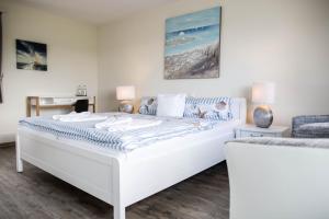 a white bedroom with a large white bed at Hotel-Restaurant Faehr-Cafe in Niesgrau