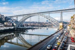 eine große Brücke über einen Fluss mit geparkten Autos in der Unterkunft Oporto Trendy River in Porto