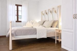a white bedroom with a bed with a white canopy at Lo Exclusive Denia Els Poblets - Villa with private pool near to beach in Els Poblets