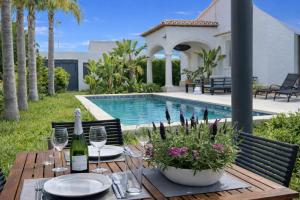 a table with wine glasses and a bottle of wine next to a pool at Lo Exclusive Denia Els Poblets - Villa with private pool near to beach in Els Poblets