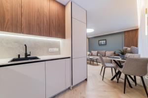 a kitchen and living room with a table and chairs at Sandal Apartments in Šiauliai