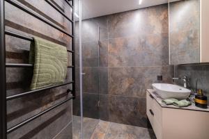 a bathroom with a sink and a shower at Sandal Apartments in Šiauliai +29 photos