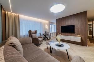 a living room with a couch and a tv at Sandal Apartments in Šiauliai