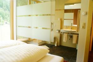 a bedroom with a bed and a sink and a mirror at Apart Flürs in Flirsch