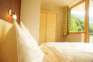 a bedroom with a white bed with a window at Apart Flürs in Flirsch