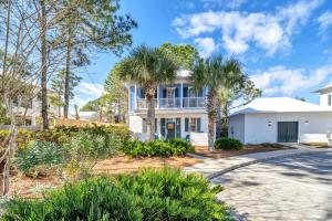 a white house with palm trees and a driveway at Blue Sky Bungalow 156 in Seagrove Beach