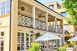a building with a balcony with tables and umbrellas at Backstage Hotel Stockholm in Stockholm